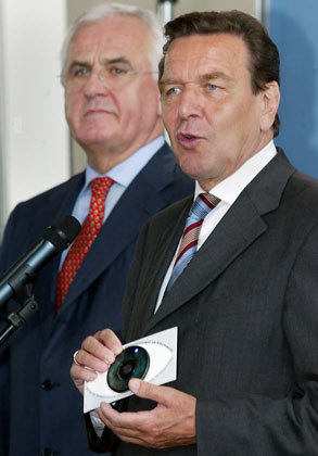 Peter Hartz remettant à Gerhard Schroeder dans la cahtédrale française de Berlin un CD-ROM contenant ses propositions de lois